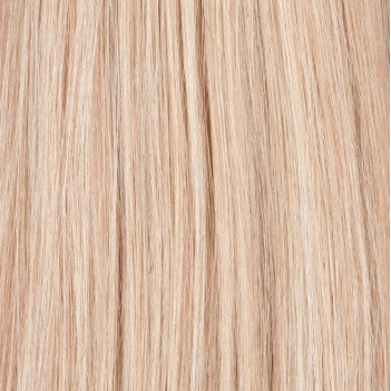 A person with blonde hair is shown from the shoulders up, wearing a gray top and a necklace. The focus is on the hair, which appears to be a weft hair extension.